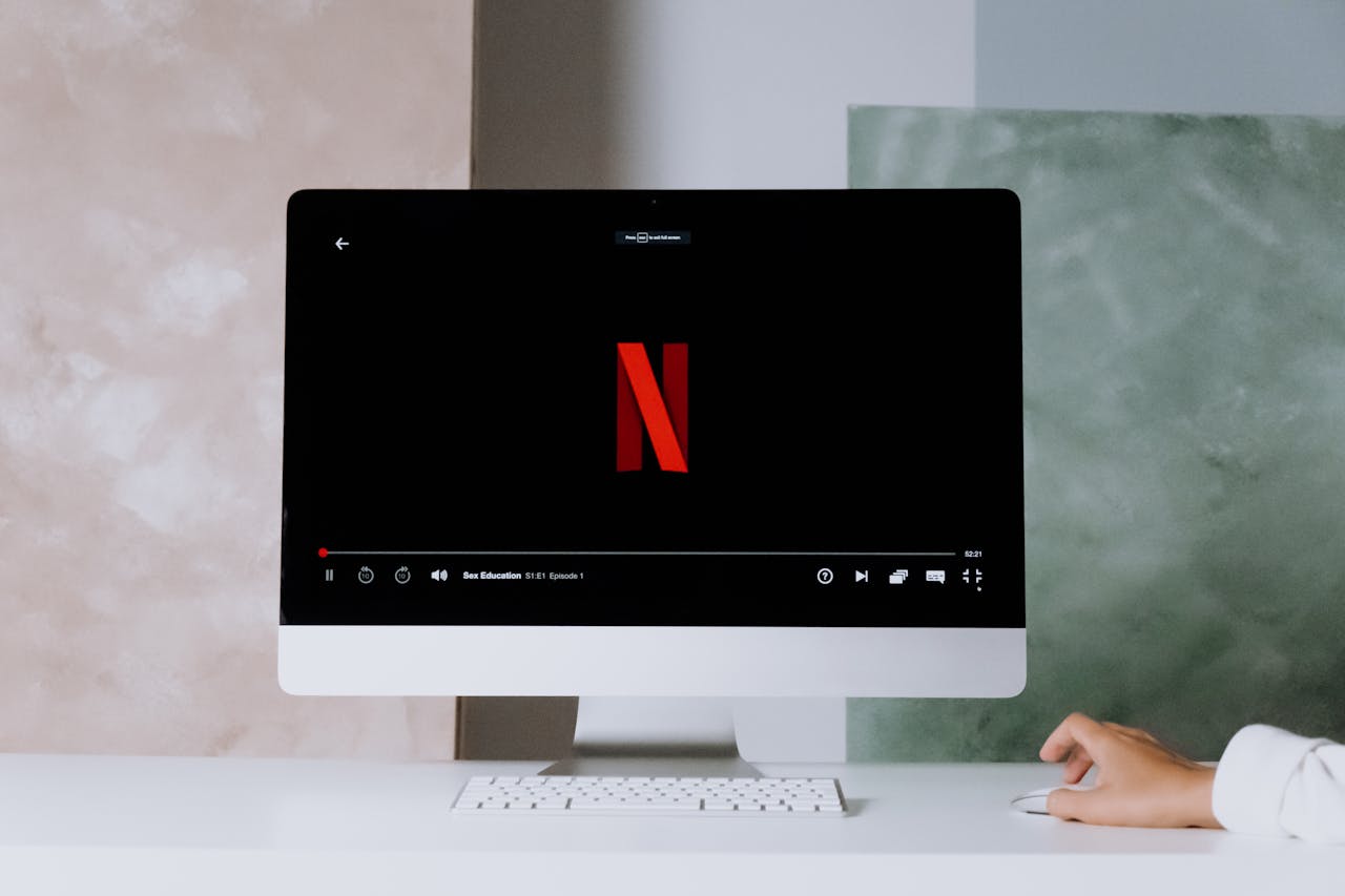 A minimalist workspace scene featuring a desktop displaying a streaming service, ideal for modern lifestyle themes.